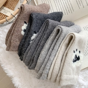 Gros plan de cinq paires de chaussettes en laine épaisses avec imprimés pattes de chat mignons