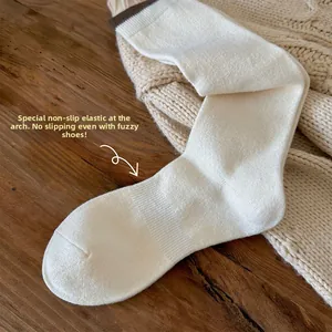 Detail view of cream knit stockings with ribbed arch support and brown contrast trim