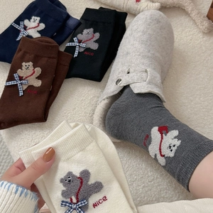 Detailed close-up of winter thermal socks featuring cute flocked bear with bow tie detail
