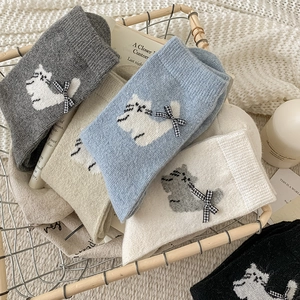 Detail of wool socks with plaid bows and cat patterns in a cozy lifestyle setting