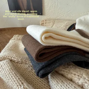 Close-up of stacked wool and mulberry silk blend socks in natural earthy tones