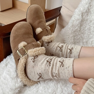 Close-up of warm brown suede winter mule with faux fur lining and gold buckle detail