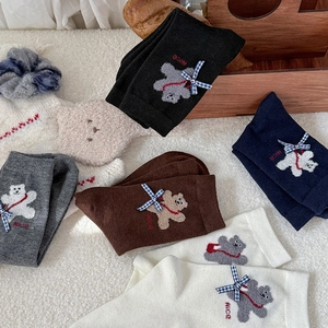 Close-up of cute flocked bear embroidery and bow details on thick winter socks