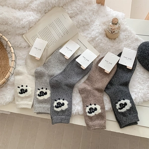 Détail de cinq paires de chaussettes en laine avec broderie mouton et étiquettes