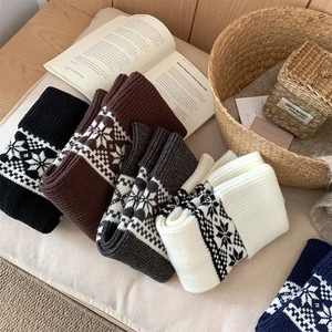 Detail of five-color Fair Isle knit leg warmers with Nordic snowflake patterns for winter