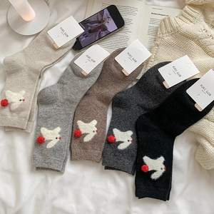 Detailed set of thick wool socks with bird embroidery and fuzzy pom-poms in five colors