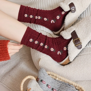 Detail of red floral wool socks with white and orange patterns for winter warmth