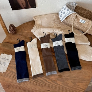 Close-up of five pairs of minimalist wool blend socks in autumn colors on a wooden table