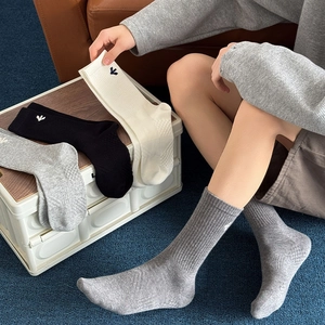 Detail of ribbed cuffs on cotton mid-calf socks with small logo embroidery