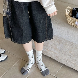 Detail of white cotton tabi socks with cute puppy patterns and dark grey split toes