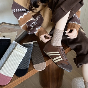 Close-up of ribbed knit crew socks in various colors paired with retro sneakers