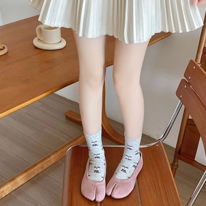 Pink Tabi shoes styled with grey cartoon dog socks and a white pleated skirt detail