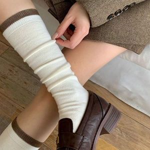 Detail of vintage cream-colored wool stockings with brown stripes and knit texture