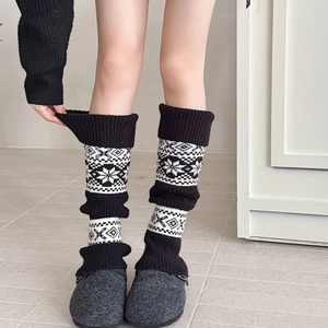Close-up of Fair Isle knit leg warmers with snowflake pattern and thick thermal texture