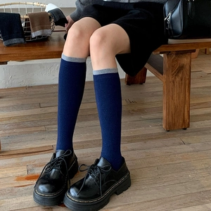Navy blue and grey patchwork knee high wool socks styled with black leather shoes