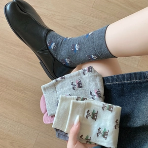 Close-up of knit crew socks with cute puppy jacquard worn with black Tabi style shoes