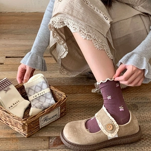 Détail de chaussettes à fleurs avec dentelle et chaussures Mary Jane à bouton en bois