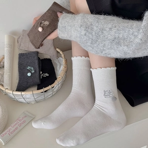 Detail von Socken mit Rüschensaum, niedlicher Katzenstickerei und 3D-Plüschball-Dekor
