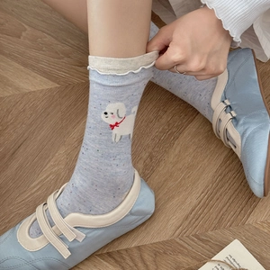 Detail of light blue ruffle sock with cute white dog print and colorful flecked texture