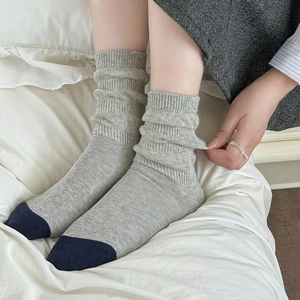 Detail of grey knitted mid-calf socks with contrast navy toe and ribbed texture