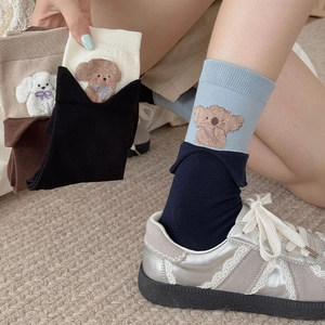 Detail of cute blue crew socks featuring a soft 3D flocked puppy on the ribbed cuff