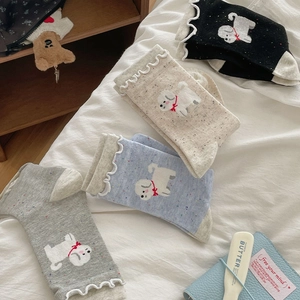 Detail of knit socks with ruffle trim and cute embroidered puppy with a red bow