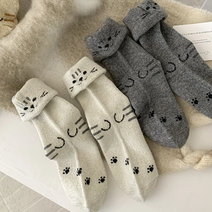 Detailed close-up of thick winter wool socks with cute cat paws and folded cuffs