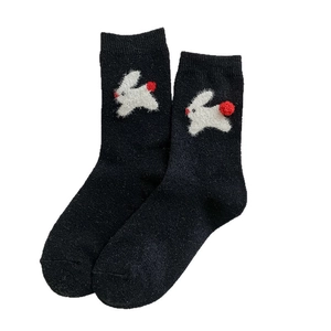 Cute black rabbit wool socks with white bunny pattern and red plush pom-poms for winter