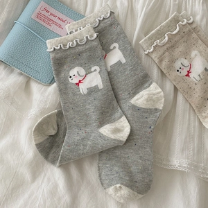 Detail view of cotton crew socks featuring cute cartoon puppies and ruffled cuffs