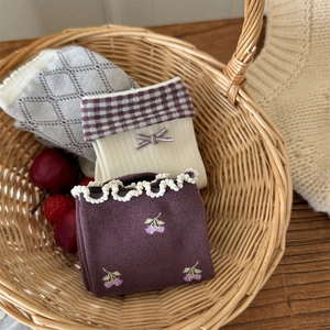 Détail de chaussettes vintage avec nœuds et dentelle dans un panier tressé