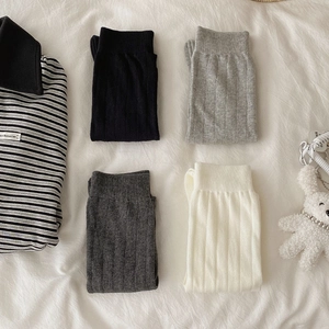 Detailed flat lay of ribbed knit mid-calf socks in black, grey, and cream cotton blend