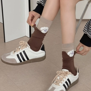 Cute beige and brown knit crew socks featuring a small puppy embroidery on a model