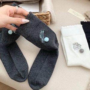 Detail mit Katzenstickerei und 3D-Pompons an gerüschten Wollmischsocken für Damen