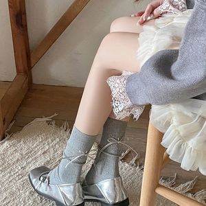Close-up of light grey crew socks with silver rhinestone butterfly and silk ribbon bow