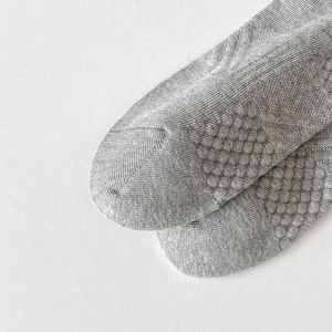 Detail of gray athletic socks featuring anti-slip honeycomb grip soles for traction