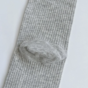 Vue macro détaillée de chaussettes en coton gris à côtes montrant la structure du talon