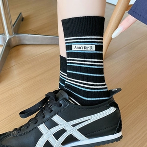 Détail de chaussettes noires à rayures avec étiquette tissée et finitions