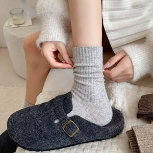 Detail of wool socks and warm felt clogs with cozy faux shearling lining and metal buckle
