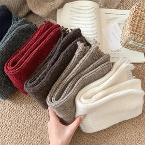 Close-up of thick ribbed knit leg warmers in various colors showing soft wool texture
