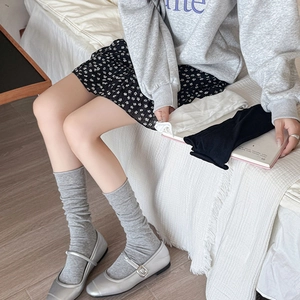 Detailed texture of ribbed knit slouch socks in gray, white and black ballet style