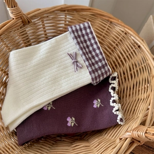Détails de chaussettes à fleurs vintage avec nœuds dans un panier tressé