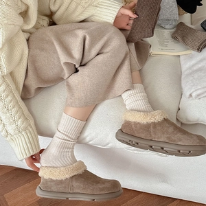 Detail of warm khaki suede boots with plush faux fur trim and thick non-slip soles