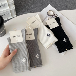 Detail view of four-pair cotton socks set in black, white, and grey with side embroidery
