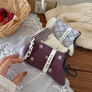 Détail de broderie florale, bordure dentelle et nœud sur des chaussettes en coton