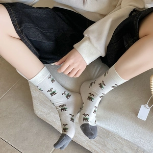 Detail of white cotton mid-tube socks with cute brown puppy patterns and grey contrast toe
