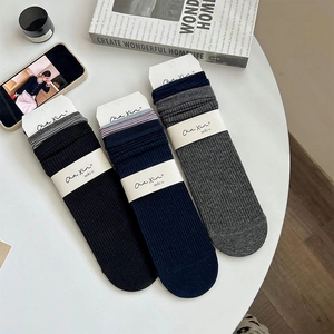 Détail macro de chaussettes mi-hautes côtelées avec bords rayés en noir, bleu et gris