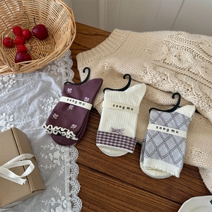 Détail de chaussettes en tricot à fleurs et nœuds sur un fond en bois chaleureux