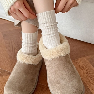 Women's warm suede snow boots with white faux fur lining and beige wool crew socks