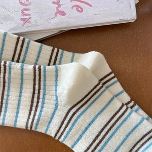 Détail de chaussettes en cachemire à rayures verticales bleues et brunes en maille côtelée