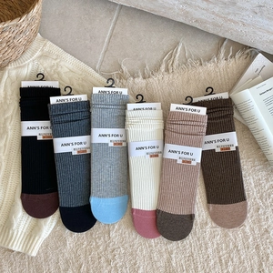Close-up of six pairs of ribbed cotton mid-calf socks in various contrasting color combinations